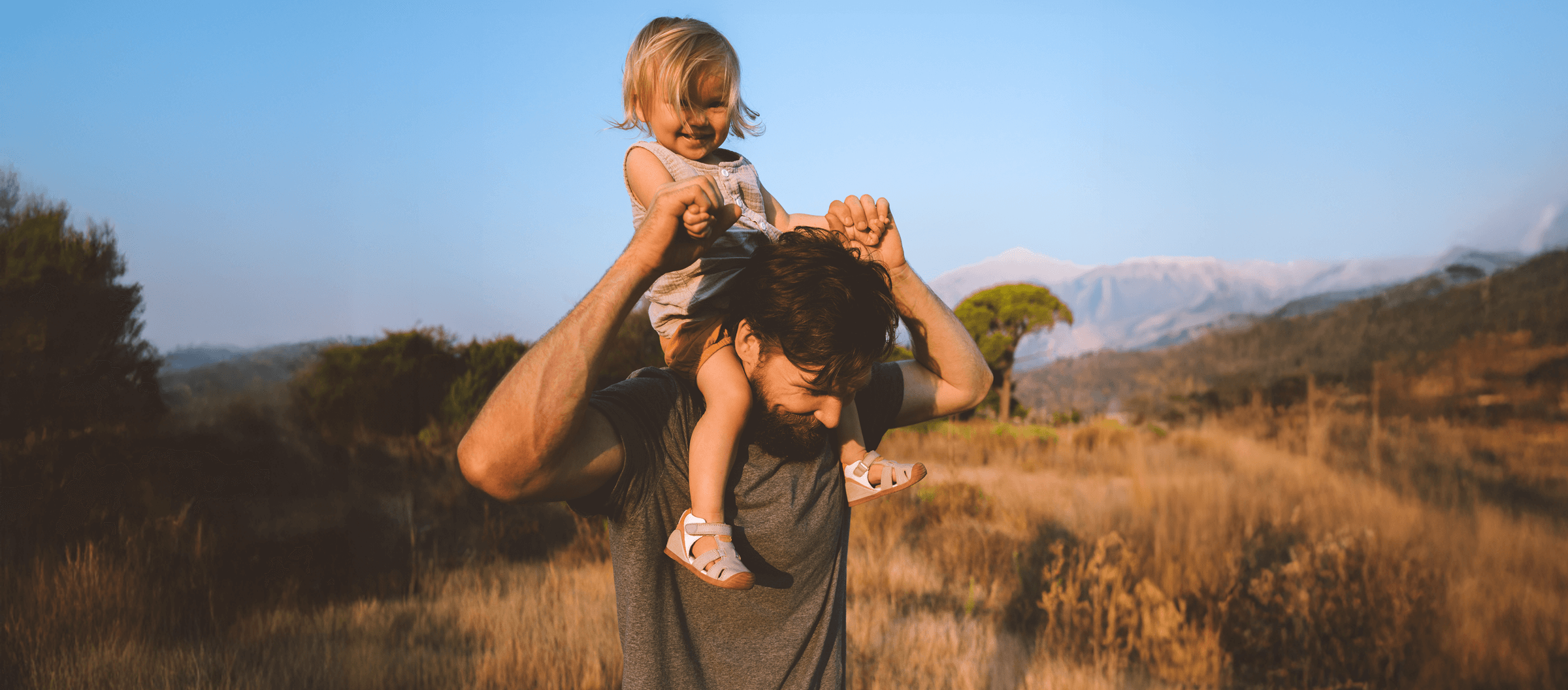 Photo of a man with a child sitting on his shoulders
