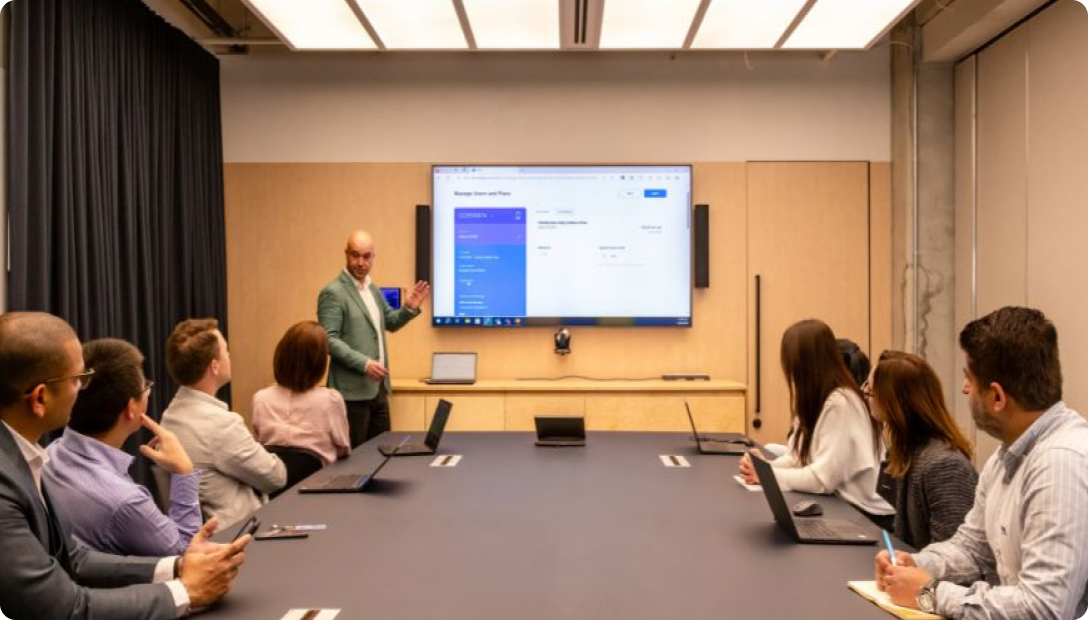 Image in a boardroom of a man presenting to a table of people