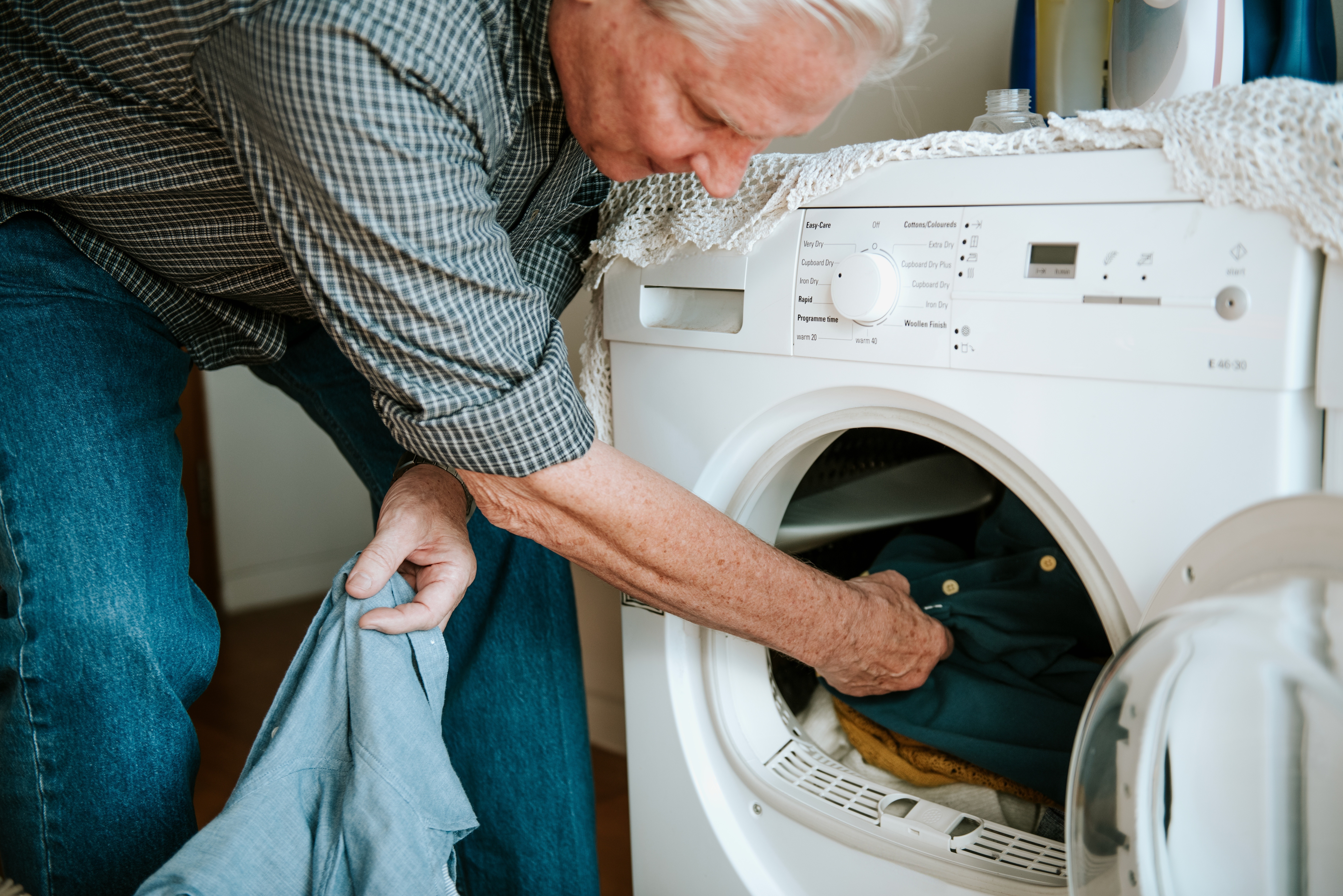 Image of a man loading his washing machine