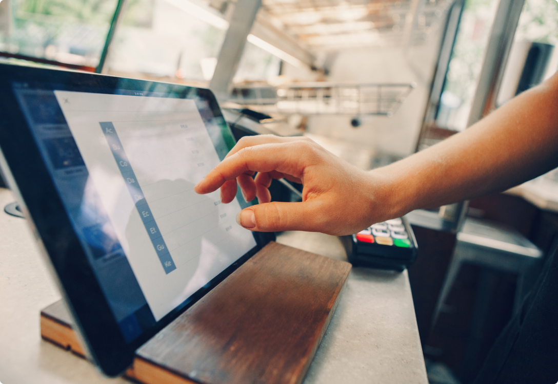 Image of a finger tapping on a point of sale screen in a business