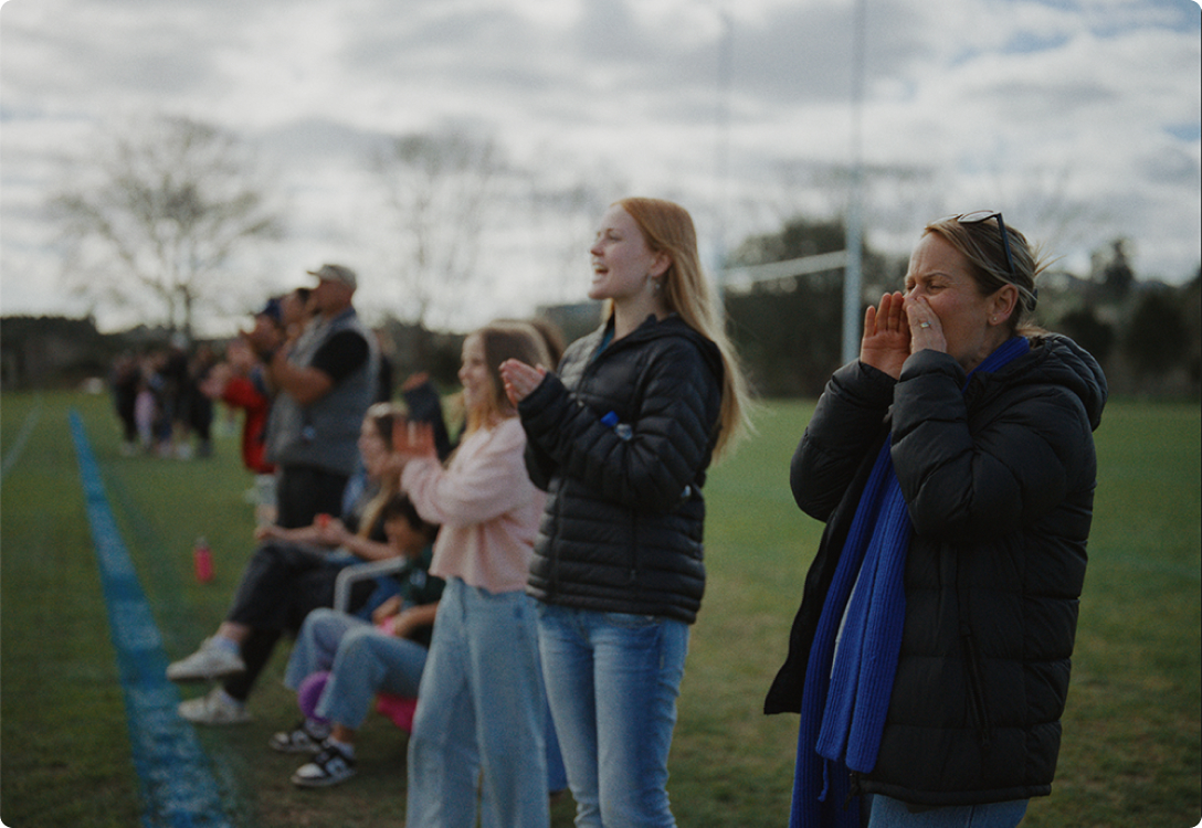 Photo of supporters on the sideline cheering