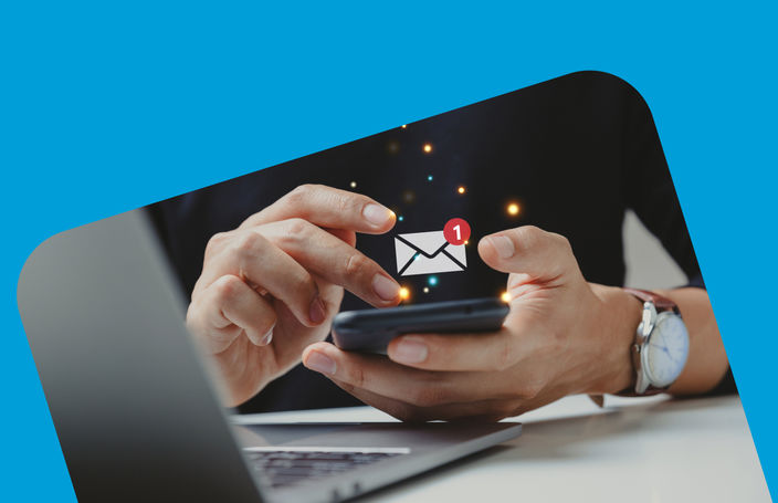 Image of a man on his phone checking his emails